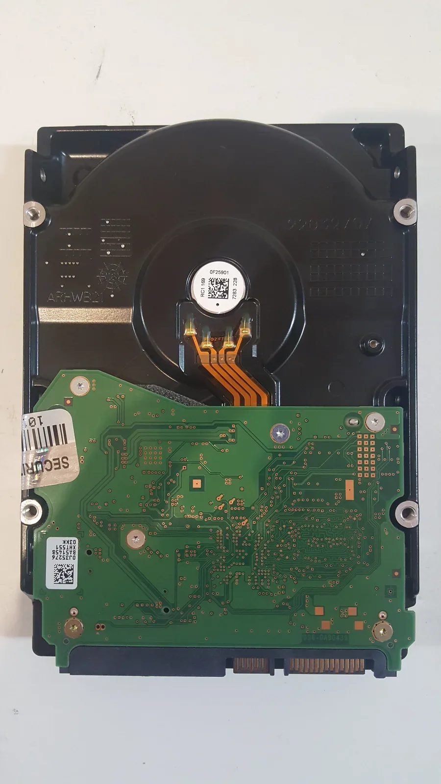 The underside of a hard drive on the repair bench.